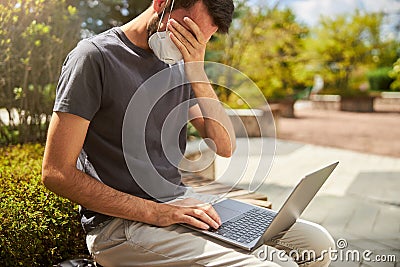 Exhausted young man sitting on the bench Stock Photo