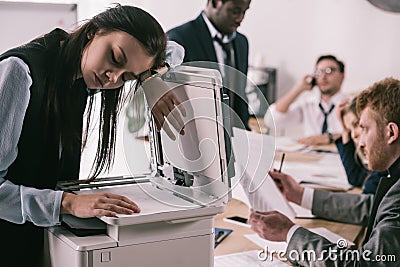 exhausted zombie like businesswoman sleeping on copier Stock Photo