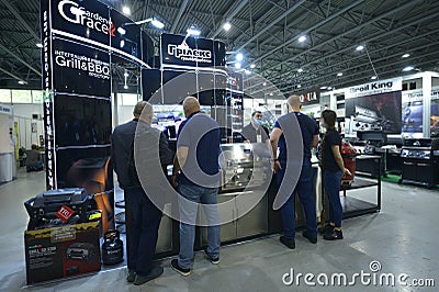 Exhibitor consulting visitor about grills presented on stand Editorial Stock Photo
