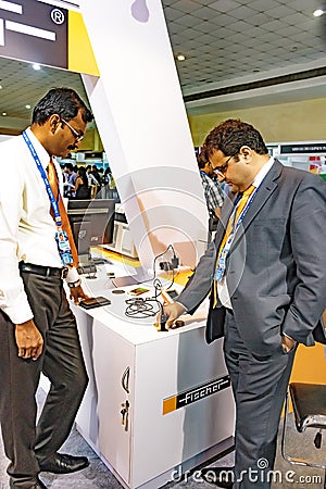 Exhibitors testing the hand held gold tester at IIJS Editorial Stock Photo
