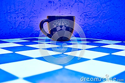 Dark cup on blue chess board and blue abstract background Stock Photo