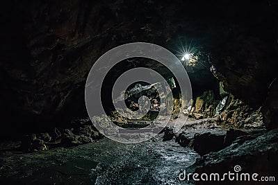 Exit from big dark scary underground cave in form of tunnel Stock Photo