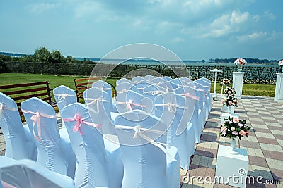 Exit registration of the newlyweds, wedding ceremony under open sky. Seating guests overlooking the river. Rows of chairs Stock Photo