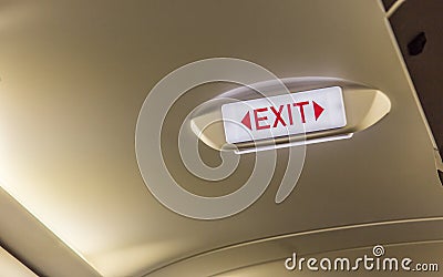 Exit sign on overhead in passenger airplane Emergency Exit Row i Stock Photo