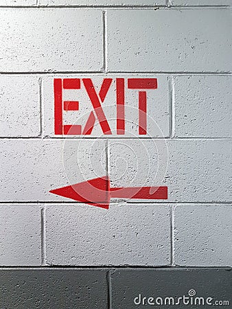 Exit text sign. Arrow red pointer exit. Emergency exit from building, wall texture. Stock Photo