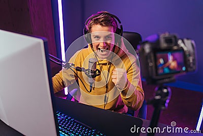 Happy pro gamer influencer shooting video on camera Stock Photo