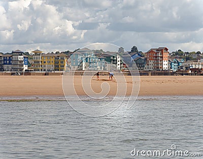 Exmouth, devon: playing on the beach. clouds Editorial Stock Photo