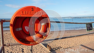 Exmouth, UK - August 03 2020: Lifebuoy ring attached to railings at the beach Editorial Stock Photo