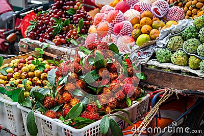 Exotic Asian fruit on local market. Asian cuisine concept.Fresh rambutans,Kiwano melon,kepundung, lemon Stock Photo