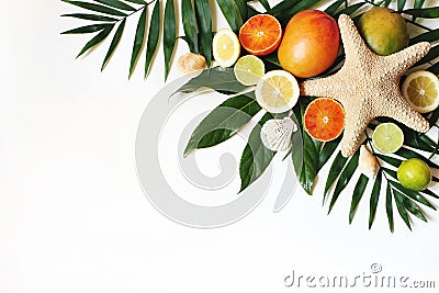 Exotic composition of seashells, starfish, mango, lemons, oranges, lime fruit and lush green palm leaves isolated on Stock Photo