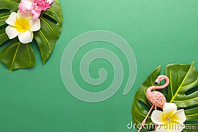 Exotic jungle summer frame. Summer beach party concept. Pink flamingo, tropical leaf monstera and orchid flowers on green Stock Photo