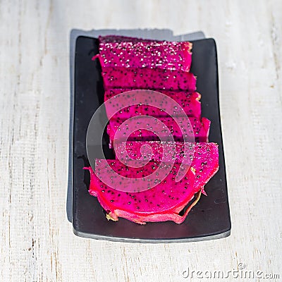 Exotic pink dragon fruit cut on background close up. Pitahaya texture photo. Sweet tropical fruit, juicy pitaya cut Stock Photo