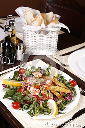 Exotic salad with shrimps, lemon, cherry tomatoes Stock Photo