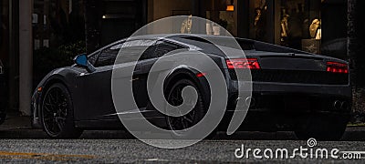 Exotic sports car parked on the street in the rain Stock Photo