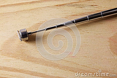 EXPANDABLE TELESCOPIC MAGNET WITH SMALL WATCH STRAP SPRING BAR CLINGING TO THE TOP Stock Photo