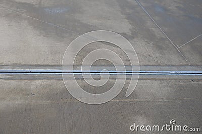 Expansion joint on the concrete roof which serves as a parking lot. dilatation consists of a rubber strip with a metal stainless s Stock Photo