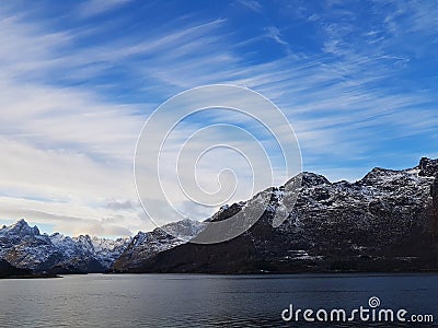 Expansive fjord in the Lofoten Islands surrounded with snowy mountains and blue sky. Norway. Stock Photo
