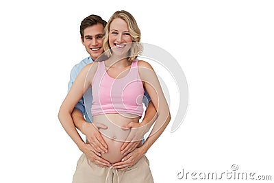 Expectant smiling parents holding mothers baby bump Stock Photo