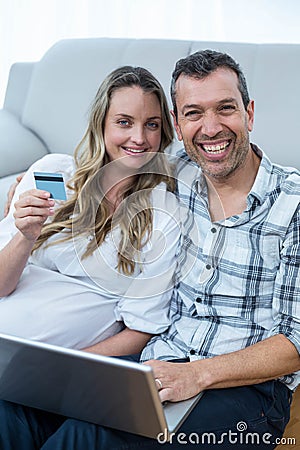 Expecting couple sitting on floor Stock Photo