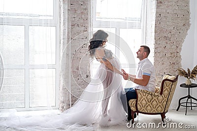 In expecting. Happy pregnant pair in fashion clothes posing in studio Stock Photo