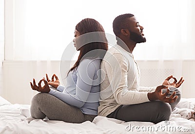 Expecting lady doing yoga with her husband at home Stock Photo