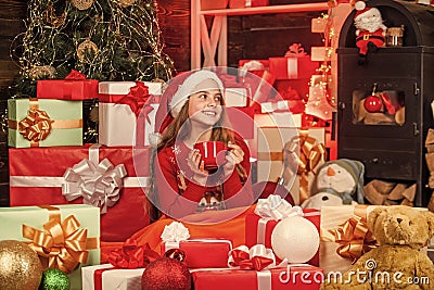 expecting Santa. christmas sale. santa helper drink milk. smiling shop assistant. kid in santa hat with many gift boxes Stock Photo