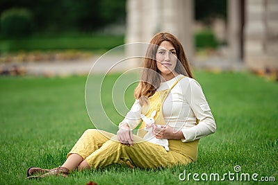 Expecting young female mother posing in park holding plush toy Stock Photo