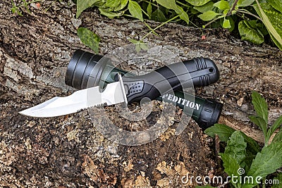 Expedition knife and flashlight waterproof on the tree trunk in the forest Vector Illustration