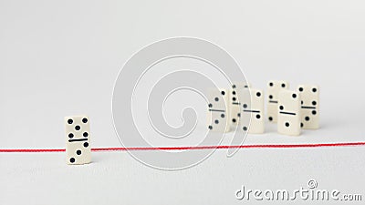 Expelled from the group, unable to cross the red line that separates them. Scene with group of domino. Concept of Stock Photo