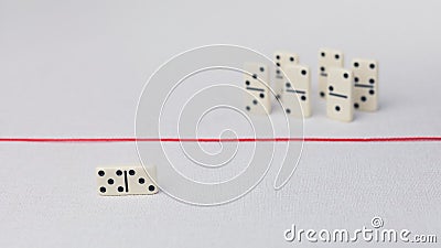 Expelled from the group, unable to cross the red line that separates them. Scene with group of domino. Concept of Stock Photo