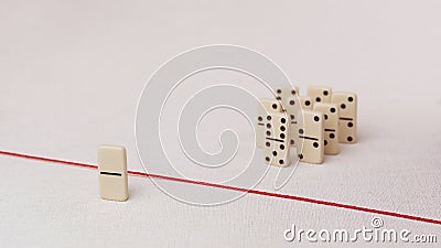 Expelled from the group, unable to cross the red line that separates them. Scene with group of domino. Concept of Stock Photo