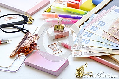 Investing time and money into education concept. Different school supplies, banknotes. Top view, close up. Stock Photo