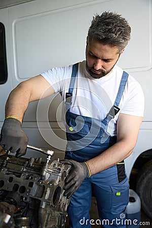 Experienced automotive technician fixing car engine in repair shop Stock Photo