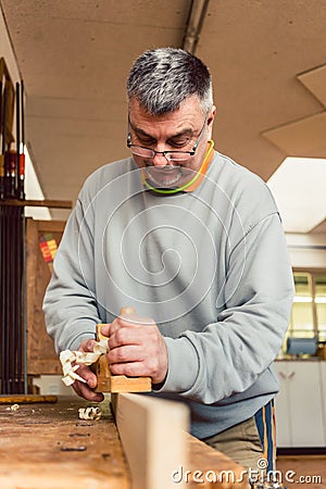 Experienced carpenter planing a board Stock Photo