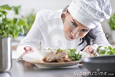 An experienced chef checks the finished food before the waiter takes it to the guest in the restaurant Stock Photo