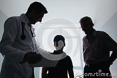 Experienced Doctor Discussing Diagnosis with a Child and Advising on Successful Therapy Solutions. His Grandfather is Stock Photo