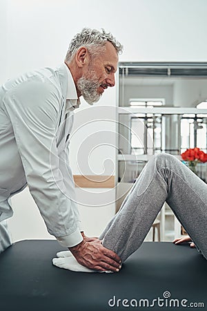 Experienced doctor performing a muscle strength test Stock Photo