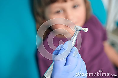 Experienced doctor preparing for polishing of female child tooth enamel Stock Photo
