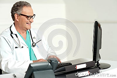 Experienced doctor working on computer Stock Photo