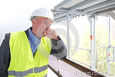 Experienced elderly construction worker, construction crew chief, construction engineer in white helmet protection inspecting at Stock Photo