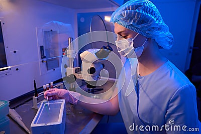 Experienced embryologist is performing cryogenic preservation of embryos in lab Stock Photo
