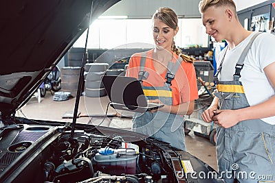 Experienced female auto mechanic checking the engine error codes Stock Photo