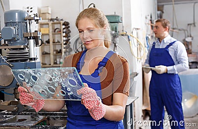 Female worker of glass factory drilling bores on machine Stock Photo