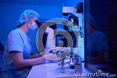 Experienced lab scientist conducting ICSI using micromanipulation device Stock Photo