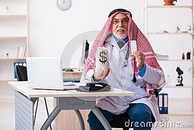 Old male arab doctor holding moneybag Stock Photo