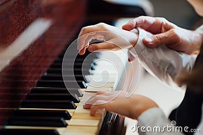 Experienced master piano hand helps the student Stock Photo