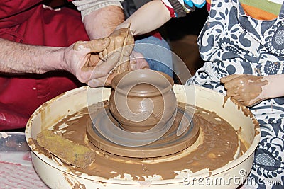 experienced master potter teaches the art of making pots clay on the's wheel Stock Photo