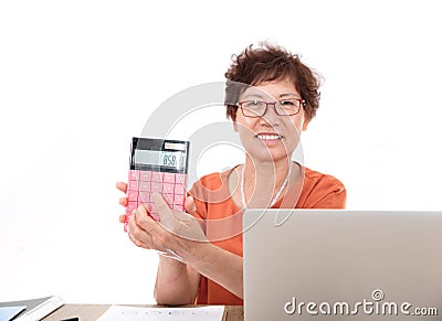An experienced middle-aged female accountant sitting at the desk happily showing the calculator in hand Stock Photo