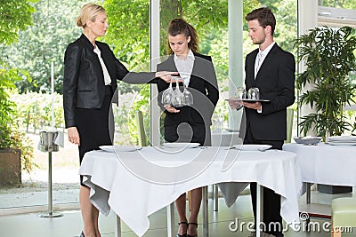 Experienced senior teacher tests students at hotel business school Stock Photo