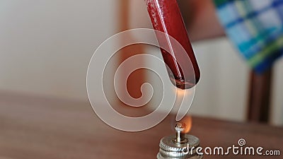 Experimenten op chemie thuis De de jongens` s handen van de close-upmening verwarmt de reageerbuis met rode vloeistof bij het bra stock videobeelden Experimenten op chemie thuis De de jongens` s handen van de close-upmening verwarmt de reageerbuis met rode vloeistof bij het bra stock videobeelden